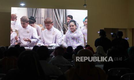  Erick Thohir Jadikan Momentum Pernikahan Kaesang-Erina Ajang Membumikan Adat Nusantara. Foto:  Warga menyaksikan prosesi adat malam midodareni jelang pernikahan Kaesang Pangarep dengan Erina Gudono melalui layar di gedung serbaguna Purwosari, Sinduadi, Mlati, Sleman, D.I Yogyakarta, Jumat (9/12/2022). Tradisi malam midodareni tersebut merupakan rangkaian acara pernikahan putra bungsu Presiden Joko Widodo, Kaesang Pangarep dengan Erina Gudono. 