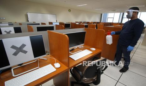 Petugas menyemprotkan cairan disinfektan di salah satu ruangan yang akan dijadikan tempat UTBK tahap pertama (5-14 Juli) di Gedung Nanizar Zaman Yoenoes, Universitas Airlangga (Unair), Surabaya, Jawa Timur, Jumat (3/7).