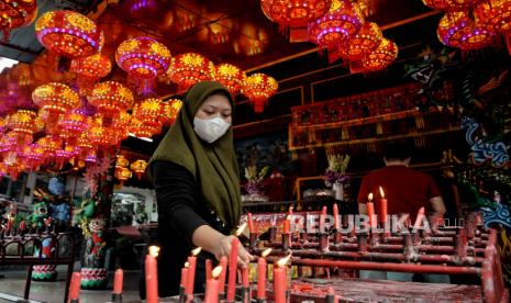 Aulia (20) salah satu pengurus vihara membersihkan lelehan lilin saat prosesi sembahyang Tahun Baru Imlek 2573 di Vihara Amurva Bhumi, Setiabudi, Jakarta Selatan, Selasa (1/2/2022). Aulia mengawali pekerjaan sebagai pengurus vihara sejak usia 12 tahun mengikuti jejak ayahnya. Baginya hidup damai berdampingan bersama warga keturunan Tionghoa merupakan bentuk toleransi sekaligus saling menghargai dalam hal perbedaan keyakinan. Repub?ika/Thoudy Badai