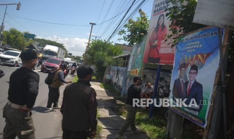 Petugas Satpol PP melepas alat peraga kampanye (APK) yang melanggar aturan. Bawaslu mengingatkan parpol tidak saling merusak alat peraga kampanye parpol lain.