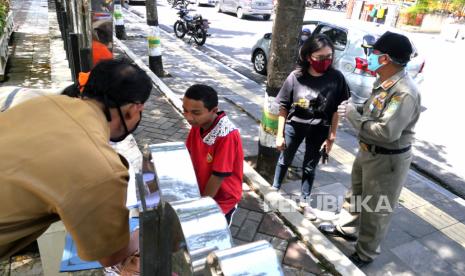 Petugas gabungan menggelar razia masker di Alun-Alun Wonosari, Gunungkidul, Yogyakarta, Selasa (15/9). Razia masker oleh TNI, Polri, Dishub, dan Satpol PP ini dalam rangka penegakan dan penyuluhan protokol kesehatan Covid-19. Bagi yang tidak bermasker diberikan penyuluhan dan diberikan masker secara gratis.