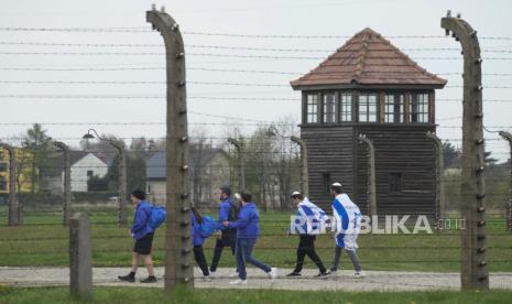 Orang-orang Yahudi mengunjungi kamp konsentrasi Nazi Auschwitz setelah perayaan tahunan March of the Living yang tidak diadakan selama dua tahun karena pandemi global COVID-19, di Oswiecim, Polandia, Kamis, 28 April 2022. Sejarah Hari Ini: Komandan Schutzstaffel Nazi Tewas Bunuh Diri