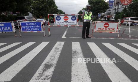 Polisi melakukan penutupan ruas jalan Jenderal Sudirman di Simpang Palma, Purwokerto, Banyumas, Jawa Tengah, Sabtu (3/7/2021). Satgas COVID-19 Kabupaten Banyumas melakukan penutupan sejumlah ruas jalan protokol, mulai pukul 14.00 -06.00 WIB selama masa PPKM darurat, untuk mengurangi pergerakan dan mencegah warga berkumpul. 