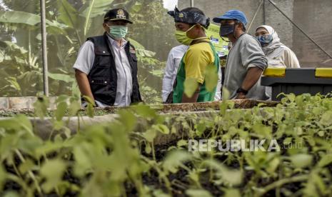 Wali Kota Bandung Oded M Danial berbincang dengan warga di Kebun Pembibitan Tanaman, Jalan Walagri Mulya, Pasanggrahan, Kecamatan Ujungberung, Kota Bandung, Rabu (6/1). Warga RW 09 Kelurahan Pasanggrahan bersama sejumlah komunitas berinisiatif membuat program Kampung Sae Hejo Co-Working yang bertujuan untuk menciptakan lingkungan yang bersih dan sehat sekaligus salah satu upaya ketahanan pangan yang hasilnya dapat dimanfaatkan oleh warga di masa pandemi Covid-19. Foto: Abdan Syakura/Republika