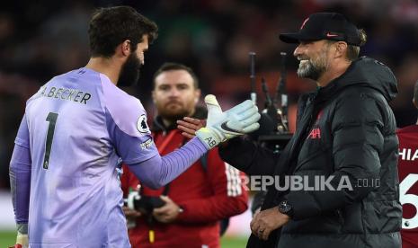 Manajer Liverpool Juergen Klopp (kanan) merayakan dengan kiper Alisson (kiri) setelah memenangkan pertandingan sepak bola Liga Premier Inggris antara Liverpool FC dan Manchester City di Liverpool, Inggris, 16 Oktober 2022.