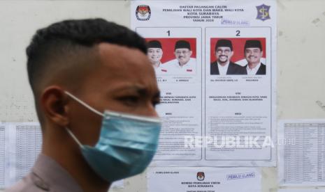 Polisi berjaga saat Pemungutan Suara Ulang (PSU) Pilkada Kota Surabaya 2020 di Tempat Pemungutan Suara (TPS) 46 Kelurahan Kedurus, Kecamatan Karang Pilang, Surabaya, Jawa Timur, Minggu (13/12/2020). PSU dilakukan karena seorang petugas Kelompok Penyelenggara Pemungutan Suara (KPPS) memberikan nomer ke sejumlah surat suara saat pemungutan suara Pilkada Kota Surabaya 2020 pada 9 Desember 2020 lalu. 