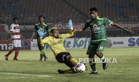 Gelandang Persebaya Surabaya Ricky R Kambuaya (kanan) berusaha menendang bola dalam pertandingan lanjutan Grup C Piala Menpora 2021 di Stadion Si Jalak Harupat, Kabupaten Bandung, Ahad (28/3). Dalam pertandingan tersebut Persebaya Surabaya berhasil mengalahkan Madura United dengan Skor 2-1. Foto: Republika/Abdan Syakura