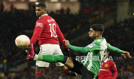  Pemain Manchester United Marcus Rashford (kiri) ditantang berebut bola dengan pemain betis  Ayoze Perez pada pertandingan sepak bola leg pertama babak 16 besar Liga Europa antara Manchester United dan Real Betis di stadion Old Trafford di Manchester, Jumat (10/3/2023) dini hari WIB.