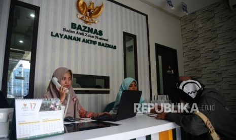 Petugas Badan Amil Zakat Nasional, melayani warga yang  datang.