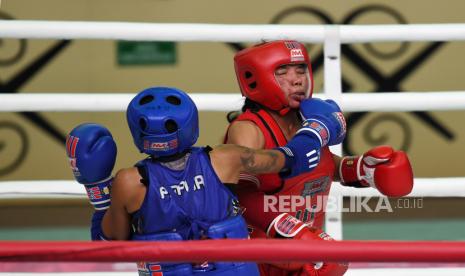 Atlet muaythai putri Jawa Barat Nur Saadah (kanan) saling memukul dengan atlet muaythai putri Papua Yael Kostantina Awom (kiri) saat bertanding pada pertandingan semifinal Muaythai Putri 43 kg PON Papua di Gor STT Gidi, Sentani, Papua, Jumat (1/10/2021). Nur Saadah menang atas Yael Kostantina Awom dan melaju ke babak final. 