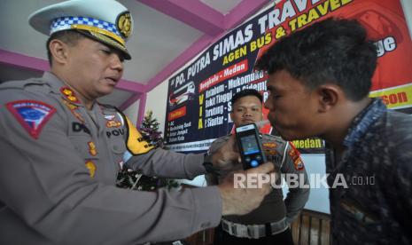 Petugas kepolisian memeriksa sopir bus menggunakan Alcoscan atau pengukur kadar alkohol saat pemeriksaan kendaraan (ramp check) di salah satu perusahaan otobus di Kota Bengkulu, Bengkulu, Senin (11/12/2023). Pemeriksaan armada bus AKAP yang meliputi pengecekan administrasi dan pemeriksaan teknis tersebut untuk mencegah potensi terjadinya kecelakaan lalu lintas akibat bus yang tidak layak jalan pada mudik Natal dan Tahun Baru 2023/2024. 