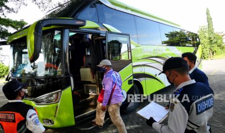 Petugas Dinas Perhubungan DIY dan Satgas Covid-19 Yogyakarta memeriksa dokumen bus pariwisata di Posko Pemeriksaan Kendaraan Libur Nataru 2021, Yogyakarta, Selasa (28/12). Posko pemeriksaan kendaraan diaktifkan kembali selama libur Natal dan Tahun Baru mulai 24 Desember 2021 hingga 2 Januari 2022. Posko pemeriksaan akan berada di kawasan Prambanan dan Tempel di Kabupaten Sleman, serta Temon, Kabupaten Kulonprogo. Selain untuk mengurangi risiko naiknya kasus Covid-19 juga untuk mengatur lalu-lintas liburan di Yogyakarta.