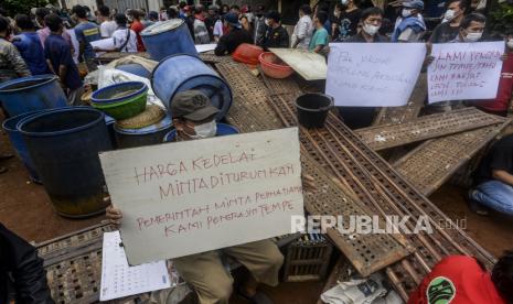 Sejumlah perajin tempe saat melakukan aksi unjuk rasa di Sentra Produksi Tempe, Cimanggis, Depok, Jawa Barat, Senin (21/2/2022). Aksi tersebut sebagai bentuk protes atas melambungnya harga kacang kedelai yang merupakan bahan baku pembuatan tempe dalam beberapa pekan terakhir dari Rp 800 ribu per kwintal hingga kini mencapai Rp 1,1 juta per kwintal. Republika/Putra M. Akbar