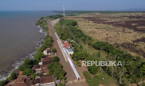 Kereta api melintas di jalur kereta di sekitar Stasiun Plabuan berdekatan dengan wilayah Kawasan Industri Terpadu Batang, di Ketanggan, Kecamatan Gringsing, Kabupaten Batang, Jawa Tengah, Rabu (26/8/2020). Kawasan Industri Terpadu Batang dengan luas lahan sekitar 4.300 hektare yang dikunjungi oleh Presiden Joko Widodo pada 30 Juni 2020 itu terintegrasi dengan jalur kereta api dan terletak di sisi utara Tol Trans Jawa, dengan pembangunan mengusung konsep 