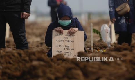 Seorang wanita berduka setelah pemakaman kerabatnya yang meninggal dengan Covid-19 (ilustrasi)