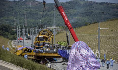 Petugas menggunakan alat berat mengevakuasi rangkaian kereta teknis proyek Kereta Cepat Jakarta-Bandung (KCJB) yang mengalami kecelakaan di Cempakamekar, Kecamatan Padalarang, Kabupaten Bandung Barat, Senin (19/12/2022). Berdasarkan keterangan Kadiv Humas Polri Irjen Dedi Prasetyo, kecelakaan tersebut menyebabkan dua warga negara China tewas serta lima orang  luka berat dan ringan. Hingga saat ini, penyebab kecelakaan kereta teknis proyek KCJB tersebut masih diselidiki pihak berwajib. Republika/Abdan Syakura