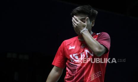 Pebulu tangkis tunggal putra Indonesia Syabda Perkasa Belawa mengusap wajahnya usai dikalahkan pebulu tangkis China Sun Fei Xiang dalam pertandingan babak pertama (64 besar) turnamen bulu tangkis BWF Tour Super 100 - Indonesia Masters 2022.