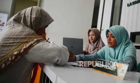 Petugas Badan Amil Zakat Nasional,melayani warga yang  datang ke kantor Baznas Tebet, Jakarta, Selasa (26/6).