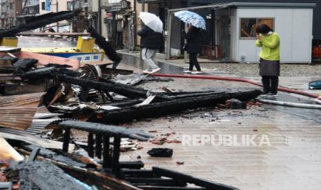 Seorang wanita berdoa di sisa-sisa yang terbakar akibat gempa bumi kuat di Wajima, Jepang tengah,  Rabu, (3/1/2024).