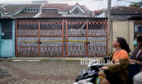 Pengendara motor melintas di dekat rumah lokasi ditemukannya empat jasad di Perumahan Citra Grand I Extenction, Kalideres, Jakarta Barat, Senin (14/11/2022). Kepolisian masih melakukan penyelidikan lebih lanjut untuk mengetahui penyebab tewasnya empat orang secara mengenaskan. Republika/Putra M. Akbar