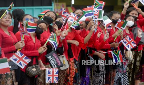 Pelajar Bali mengibarkan bendera negara anggota G20 saat kedatangan para pemimpin G20, di sepanjang jalan dekat bandara Internasional Ngurah Rai di Bali, Indonesia, 14 November 2022. KTT Kepala Negara dan Pemerintahan Kelompok Dua Puluh (G20) ke-17 akan diadakan di Bali mulai 15 hingga 16 November 2022.