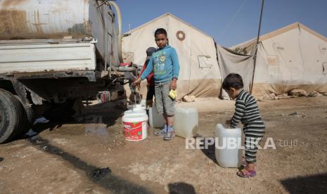 Pengungsi Suriah mengisi air dari tangki di kamp Kalbeet, Idlib utara, 29 Oktober 2022 (dikeluarkan 01 November 2022).