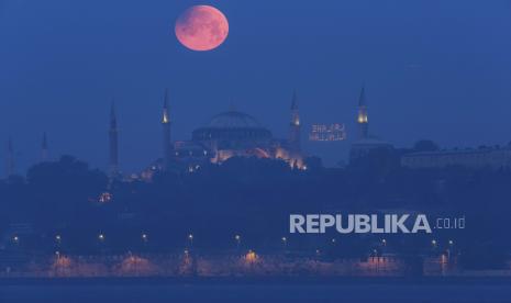  Bulan purnama muncul di atas Haghia Sophia yang ikonik di Istanbul, Turki, Senin pagi, 16 Mei 2022. Israel menjemput warganya yang sedang mengunjungi Istanbul untuk berwisata.