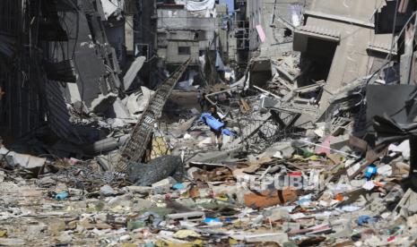 Seorang warga Palestina berjalan melewati kehancuran akibat serangan Israel di Khan Younis, Jalur Gaza, Jumat, (8/3/2024).