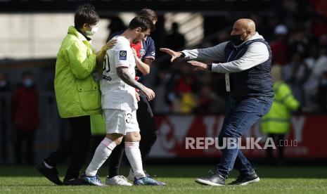  Seorang penyerang lapangan (tersembunyi) bersorak untuk pemain Paris Saint Germain Lionel Messi (kiri) saat penjaga keamanan (kanan) tiba setelah pertandingan sepak bola Ligue 1 Prancis antara Rennes dan PSG di Stadion Roazhon Park di Rennes, Prancis, 03 Oktober 2021. Dalam laga ini, PSG menyerah 0-2 dari Rennes.