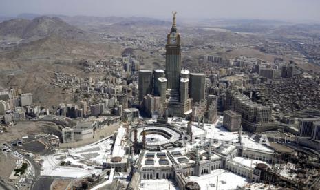 Tampilan udara menunjukkan menara jam di atas Masjidil Haram ketika para peziarah Muslim berjalan di sekitar Kabah, kubus hitam yang terlihat di tengah masjid agung, selama ibadah haji tahunan di Makkah, Arab Saudi, Selasa(10 Juli 2022). Haji tahunan Islam ziarah di Arab Saudi akan kembali ke tingkat pra-pandemi pada tahun 2023, setelah pembatasan melihat peringatan keagamaan tahunan dibatasi karena kekhawatiran tentang virus corona, kata pihak berwenang.