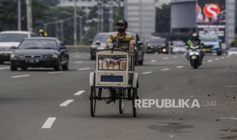 Pedagang menggunakan masker saat melintasi kawasan Sudirman, Jakarta,Ahad (11/10). Pemerintah Provinsi DKI Jakarta mengurangi kebijakan rem darurat di Ibu Kota dengan kembali memberlakukan Pembatasan Sosial Berskala Besar (PSBB) Transisi mulai Senin (12/10) hingga Senin (25/10), karena adanya pelambatan kenaikan kasus positif dan kasus aktif Covid-19 meski masih terjadi peningkatan penularan. Republika/Putra M. Akbar