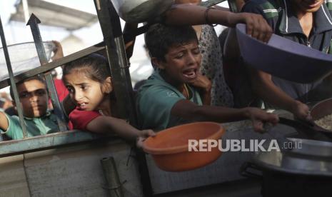 Anak-anak berteriak dan menangis saat antre mendapatkan makanan di kamp Khan Younis, Jalur Gaza Selatan. Menurut kesaksian, beberapa warga Palestina di penjara Israel meninggal selama intergoasi.