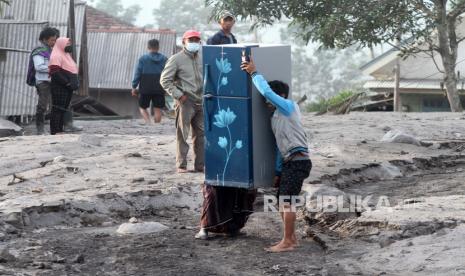 Warga menyelamatkan kulkas di kawasan yang sempat disapu awan panas guguran (APG) Gunung Semeru di Dusun Kajar Kuning, Desa Sumberwuluh, Lumajang, Jawa Timur, Senin (5/12/2022). Bencana awan panas guguran Gunung Semeru tersebut menyebabkan puluhan rumah penduduk rusak dan ratusan warga mengungsi. 