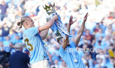 Striker Manchester City Erling Haaland mengangkat trofi gelar Liga Primer Inggris setelah pertandingan sepak bola Liga Primer antara Manchester City dan Chelsea di Stadion Etihad di Manchester, Inggris, Ahad, (21/5/2023). 