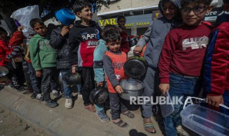 Anak-anak pengungsi Palestina antre untuk menerima makanan yang disediakan oleh relawan di kota Deir Al Balah, Jalur Gaza Selatan, Sabtu (24/2/2024). Sebanyak 1,9 juta orang telah mengungsi di Gaza akibat konflik berkepanjangan. Badan Bantuan dan Pekerjaan PBB untuk Pengungsi Palestina (UNRWA) menyatakan sebagian besar warga sipil di Gaza sangat membutuhkan bantuan kemanusiaan.