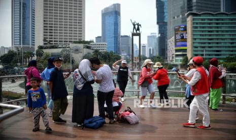 Warga berfoto di Anjungan Halte Bundaran HI saat Hari Bebas Kendaraan Bermotor (HBKB) di kawasan Bundaran Hotel Indonesia, Jakarta. Epidemiolog sebut pencabutan PPKM yang terburu-buru justru rawan sekali.