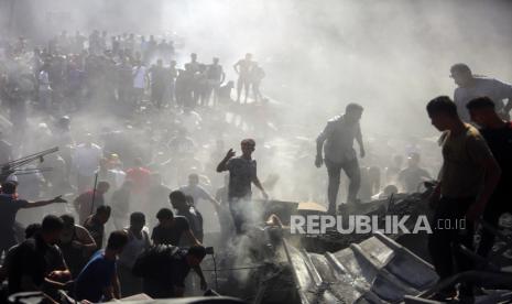 Warga Palestina memeriksa puing-puing bangunan yang hancur akibat serangan udara Israel di kota Khan Younis, Jalur Gaza selatan. Suara dukungan untuk Palestina terus digaungkan.