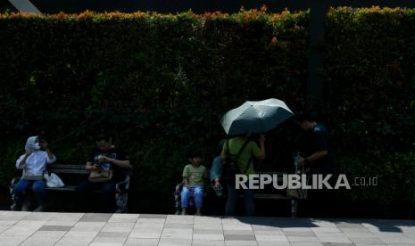 Warga beraktivitas saat cuaca terik di kawasan Bundaran Hotel Indonesia, Jakarta, Senin (24/4/2023). 