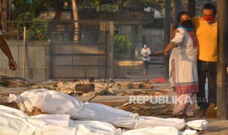 Anggota keluarga bereaksi sebelum pemakaman seorang korban yang meninggal dengan COVID-19, di tempat kremasi untuk korban COVID-19 di New Delhi, India, 10 Mei 2021. Seruan untuk penutupan secara nasional telah meningkat seiring dengan jumlah COVID- baru- 19 infeksi dan kematian terkait berdiri mendekati rekor tertinggi pada 10 Mei.