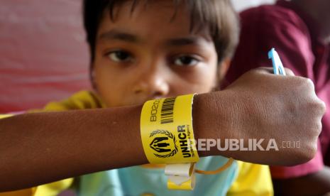 Seorang anak imigran etnis Rohingya memperlihatkan gelang pengenal dari UNHCR saat berada di dalam tenda di kawasan komplek kantor Bupati Aceh Barat, Aceh, Rabu (27/3/2024). Pemerintah Kabupaten Aceh Barat menempatkan sementara 75 orang pengungsi Rohingya di kawasan komplek perkantoran Bupati Aceh Barat setelah sebelumnya ditempatkan di Gedung Palang Merah Indonesia (PMI) Desa Suak Nie dan mendapatkan pengusiran dari sebagian masyarakat setempat. 