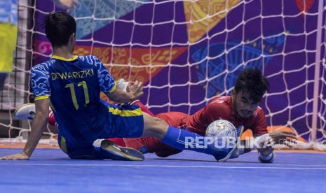 Atlet futsal Jawa Barat Dewa Rizki (kiri) berebut bola dengan penjaga gawang futsal Nusa Tenggara Barat Muhammad Wildan (kanan) saat bertanding pada semi final Futsal PON Papua di Gor SP 2, Kabupaten Mimika, Papua, Jumat (1/10/2021). Tim futsal Jawa Barat berhasil melaju ke final usai mengalahkan tim futsal Nusa Tenggara Barat dengan skor akhir 1-0. 