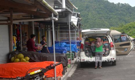 Pedagang cenderamata mengevakuasi dagangan pascaawan panas guguran (APG) di kawasan wisata Kali Adem, Sleman, Yogyakarta, Kamis (10/3/2022). Pengelola destinasi wisata di Sleman, Yogyakarta buat gerakan kebersihan serentak.