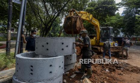 Pekerja saat menyelesaikan pembuatan sumur resapan di kawasan Kebayoran Baru, Jakarta Selatan, Selasa (12/10). 