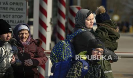 Pengungsi berangkat ke Rumania setelah melarikan diri dari Ukraina, berjalan di perbatasan di Palanca, Moldova, Kamis, 17 Maret 2022. PBB mengatakan perang Rusia-Ukraina telah mengusir 10 juta orang dari rumah mereka. 