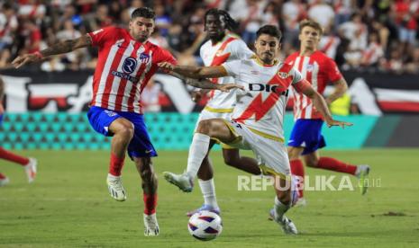 Pemain Atletico Madrid Rodrigo de Paul (kiri) berduel dengan Oscar Valentin dari Rayo Vallecano pada laga La Liga 2023/2024, Selasa (29/8/2023). 