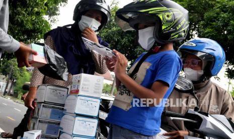 Warga membeli masker medis di penjual masker dadakan di Yogyakarta, Kamis (24/6). 