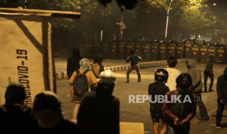 Sejumlah demonstran bentrok dengan polisi saat aksi unjuk rasa menolak Undang-Undang Cipta Kerja (UU Omnibus Law) di Jalan Sultan Alauddin, Makassar, Sulawesi Selatan, Kamis (8/10/2020) malam. Bentrokan terjadi saat polisi berusaha membubarkan pengunjuk rasa yang masih bertahan hingga malam hari. 