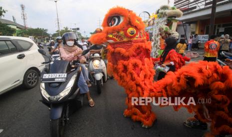 Barongsai membagikan takjil kepada pengguna jalan saat kegiatan bagi-bagi takjil umat Buddha dari Wihara Dharma Bhakti Sidoarjo di jalan Ponti, Sidoarjo, Jawa Timur, Ahad (24/3/2024). Kegiatan berbagi tersebut merupakan bentuk kepedulian antarumat beragama terutama di bulan Ramadhan. 