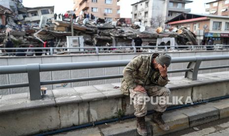  Seorang tentara Turki menangis di depan bangunan yang runtuh di Hatay, Turki, Selasa (7/2/2023). Ribuan orang meninggal ribuan lainnya terluka setelah gempa bumi besar melanda Turki selatan dan Suriah utara pada 06 Februari. Pihak berwenang khawatir jumlah korban tewas akan terus meningkat karena tim penyelamat mencari korban selamat di seluruh wilayah.