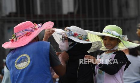 Warga memakai topi yang disewakan saat mengunjungi kompleks Museum Fatahilah di kawasan Kota Tua, Jakarta, Rabu (16/3/2022). Obyek wisata di Ibu Kota mulai ramai dikunjungi warga pada masa PPKM level dua yang diikuti pelonggaran sejumlah aktivitas masyarakat. 